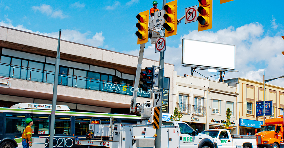 Traffic signalization work commencing during regular work hours in an active street.